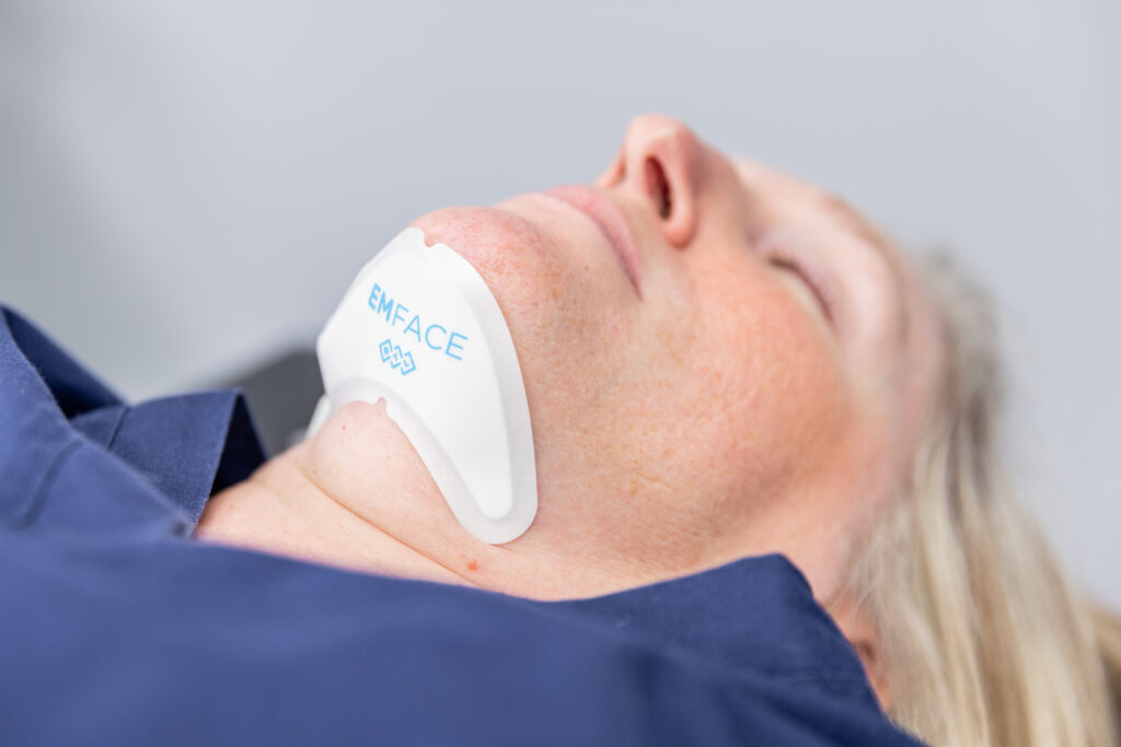 A patient receiving their treatment for a necklift in Mechanicsville using the Emface device.